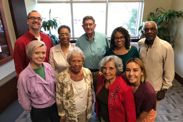 Group of seniors and family caregivers smile and pose