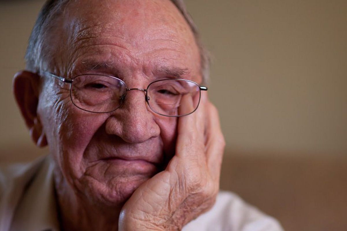 Senior resting his face in his hands